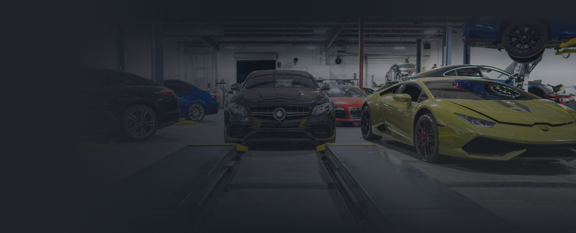 A row of cars are parked in a garage | Adler Rennsport