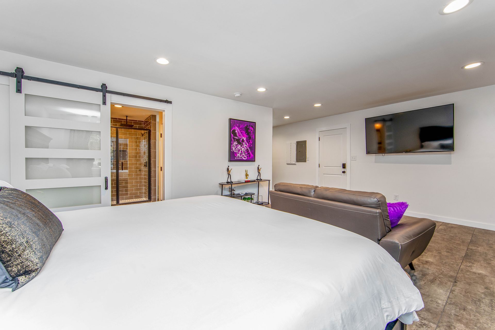 A bedroom with a large bed , couch and television.