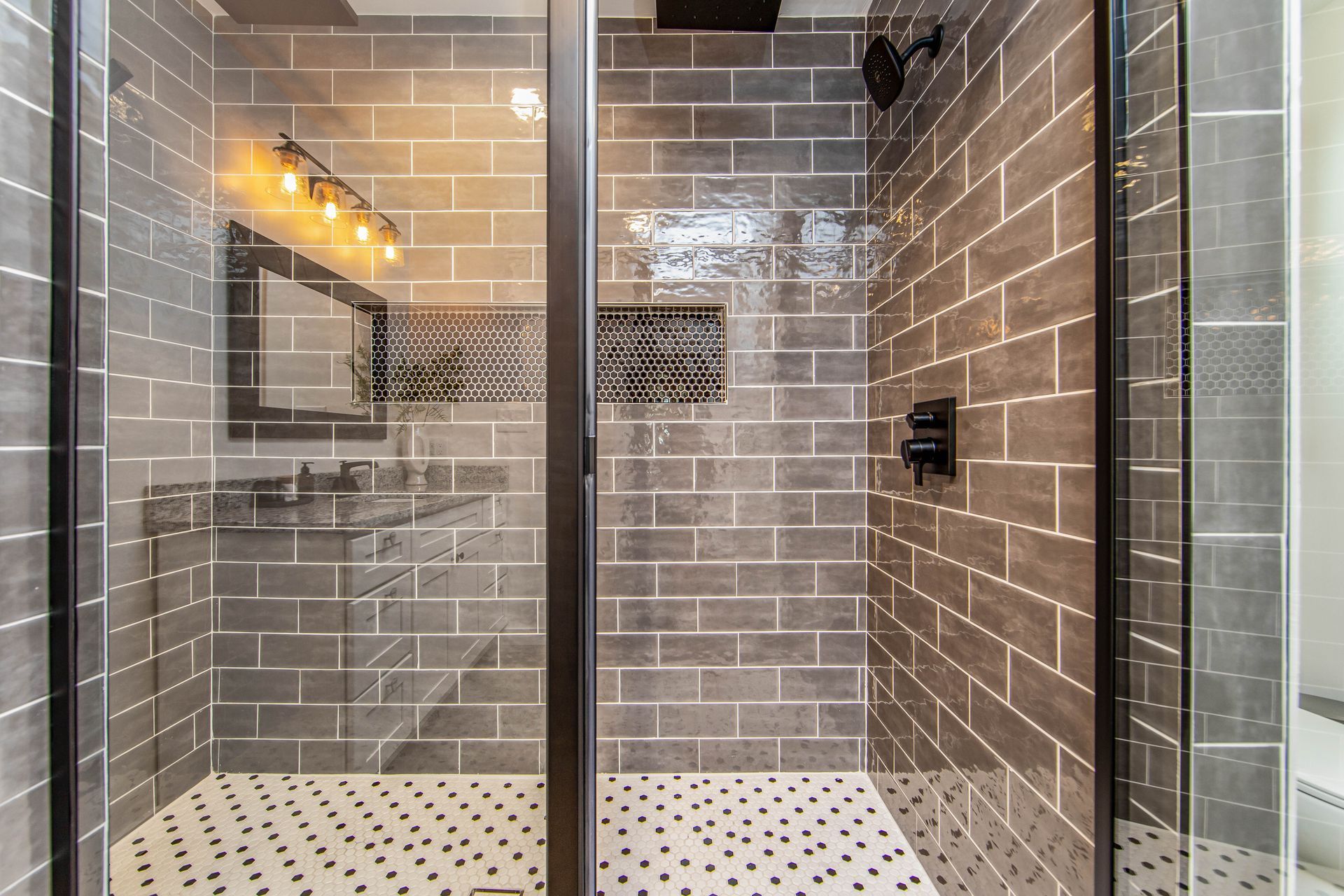 A bathroom with a walk in shower with a glass door.