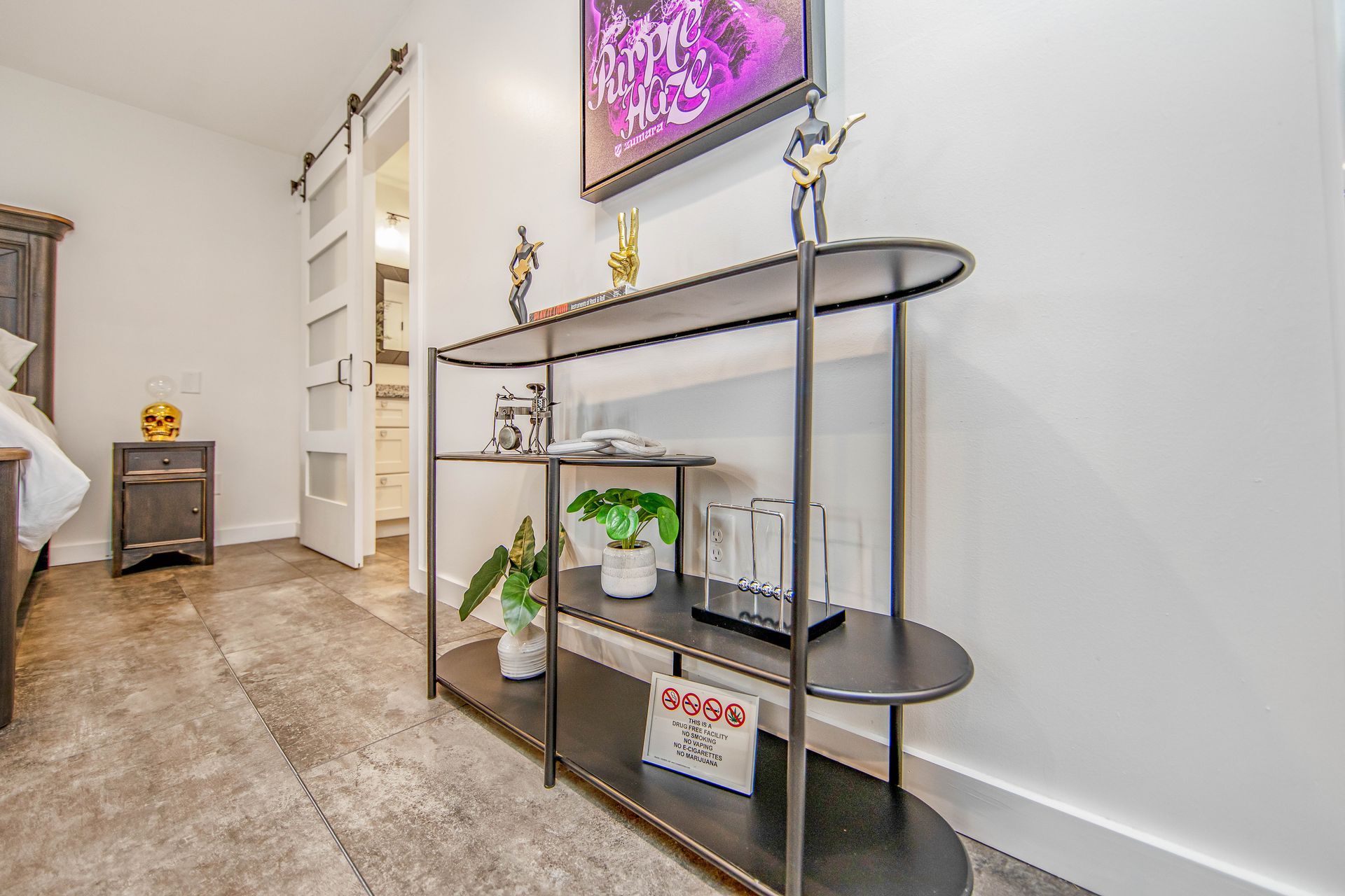 A bedroom with a shelf and a television on the wall.