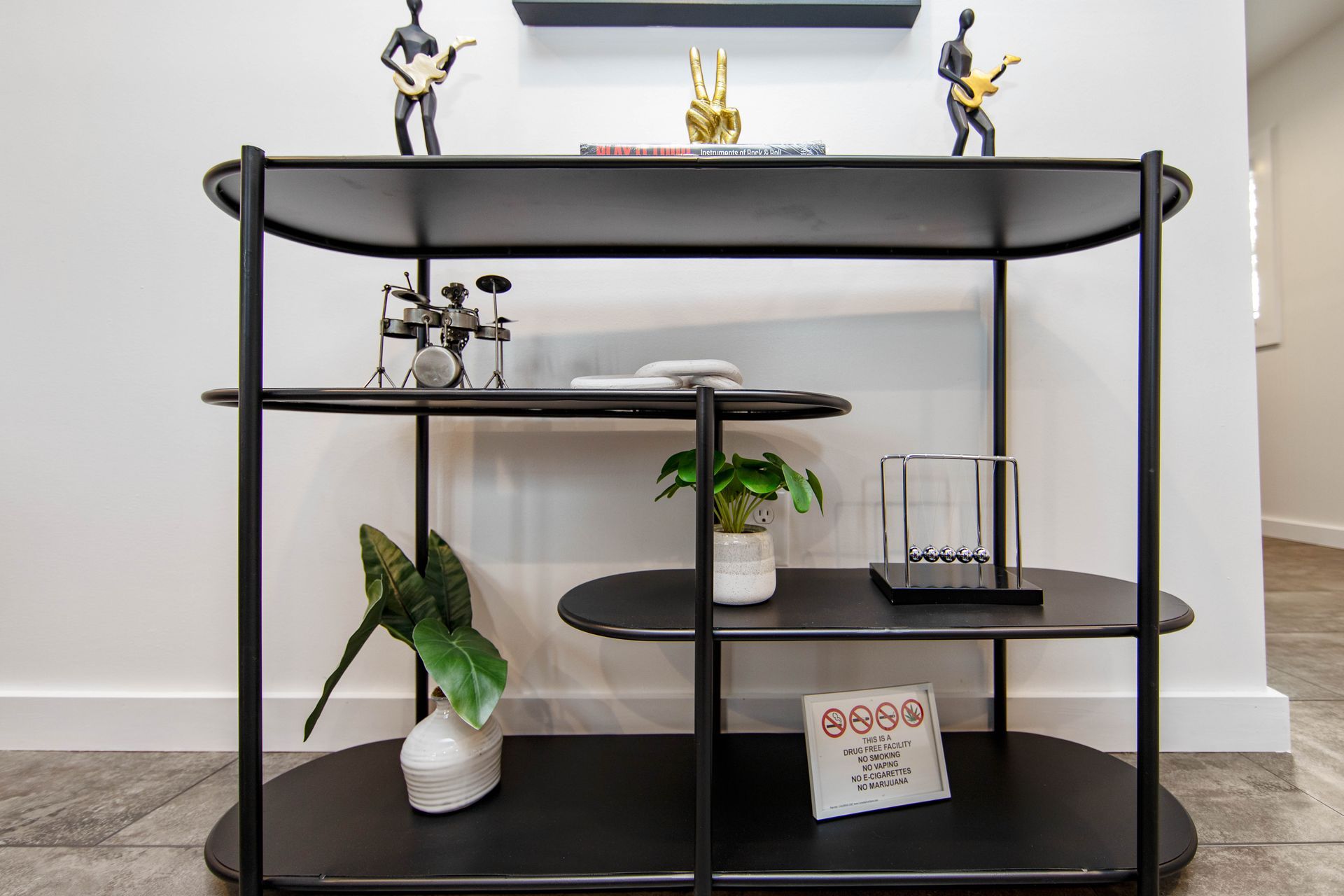 A black shelf with figurines on top of it in a room.