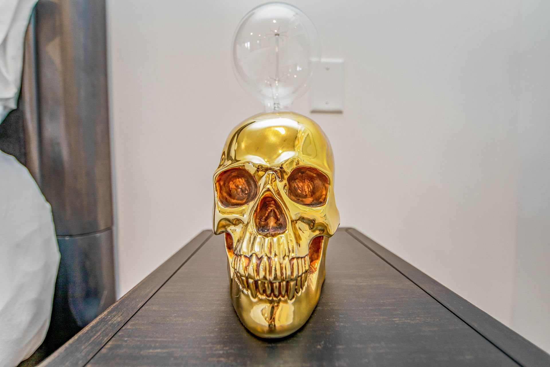 A gold skull is sitting on top of a wooden table.