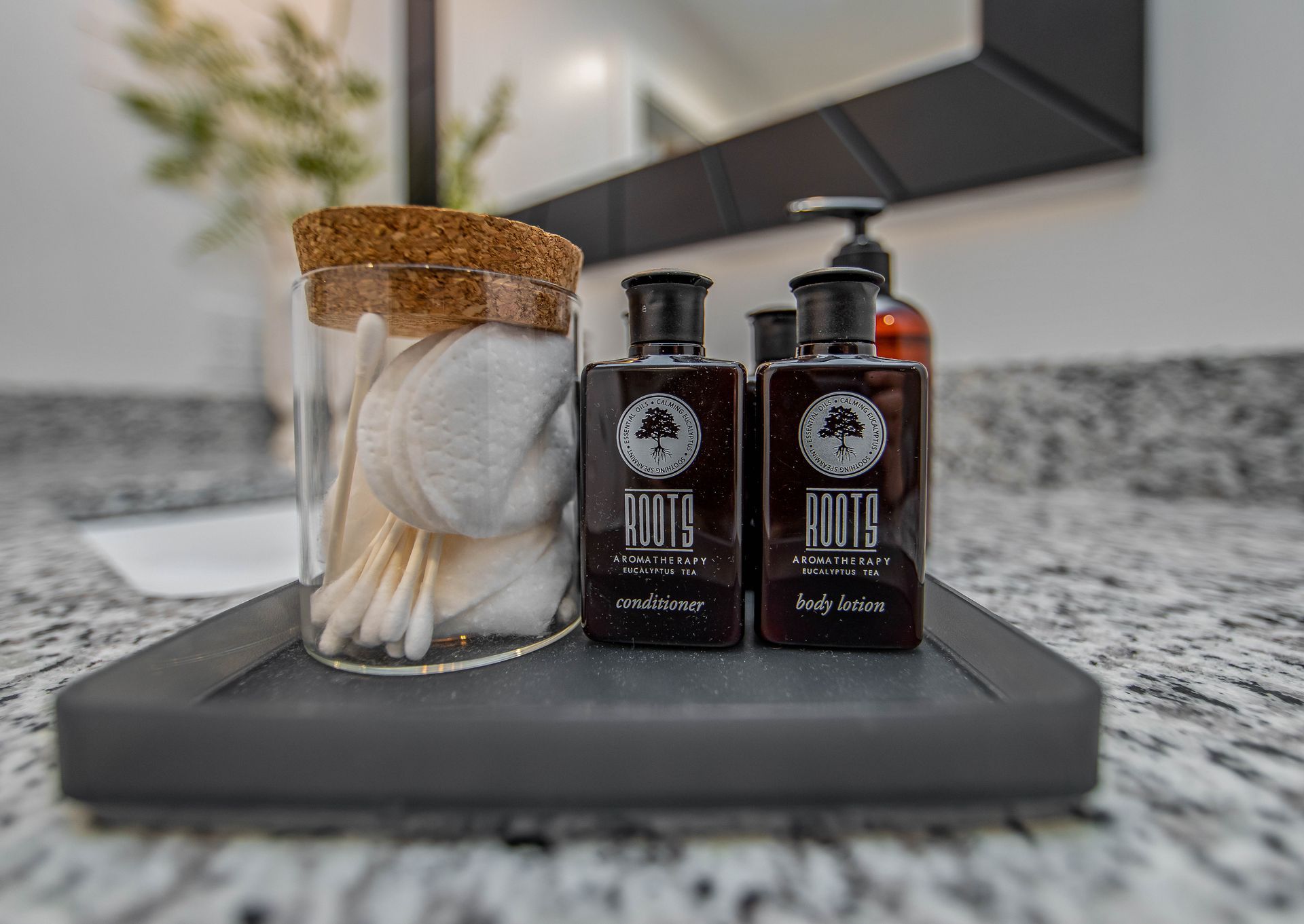 A bathroom counter with two bottles of lotion and cotton swabs on it.