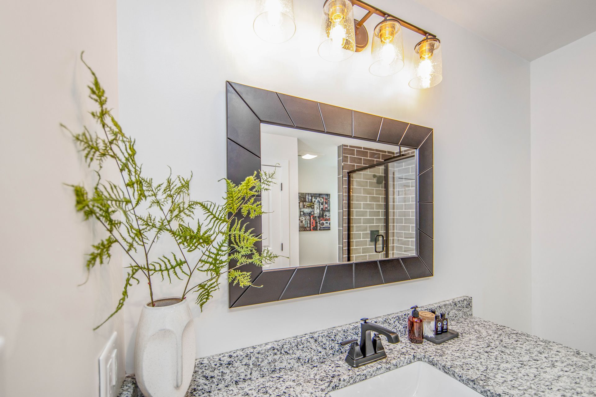 A bathroom with a large mirror and a sink.