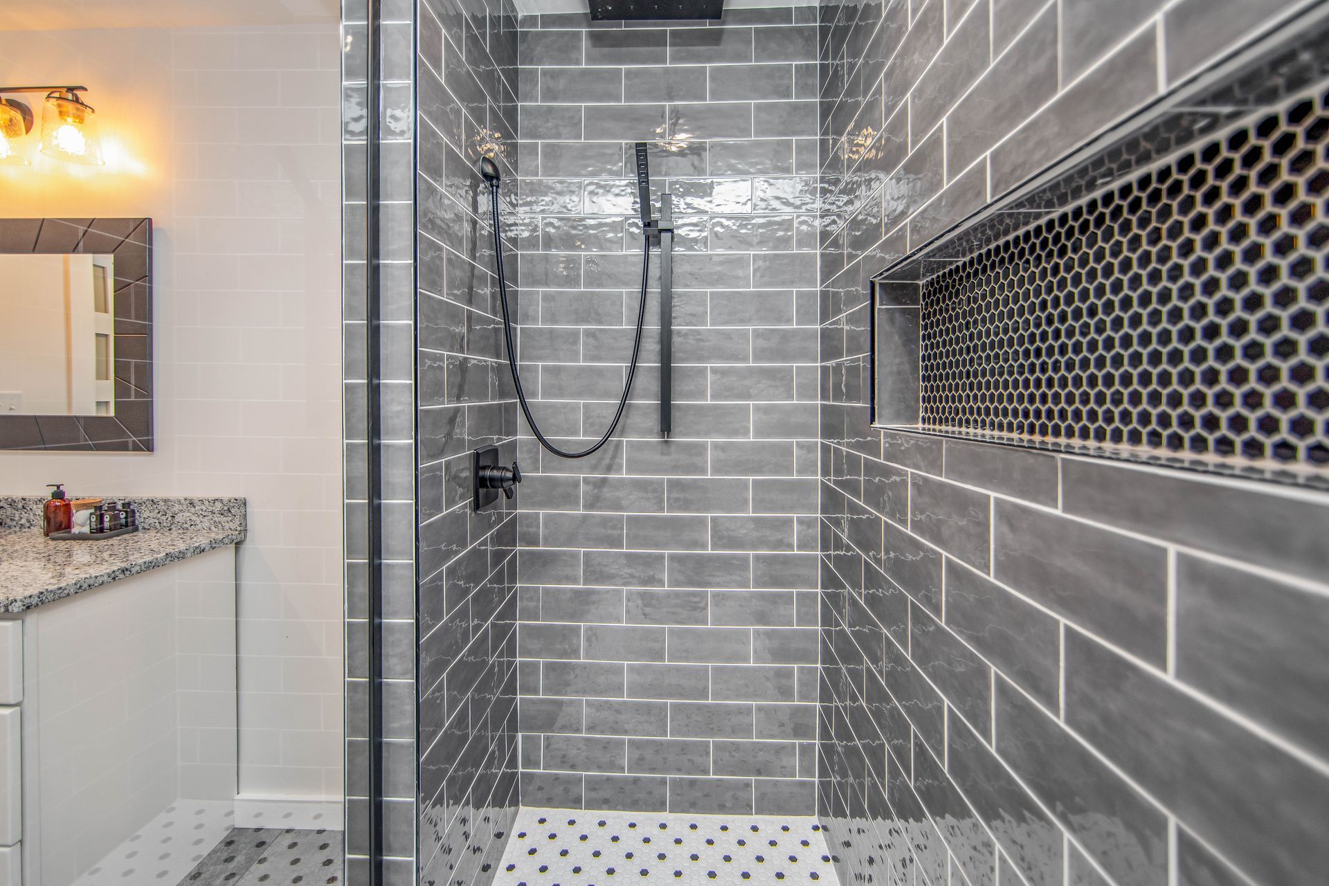 A bathroom with a walk in shower and a mirror.