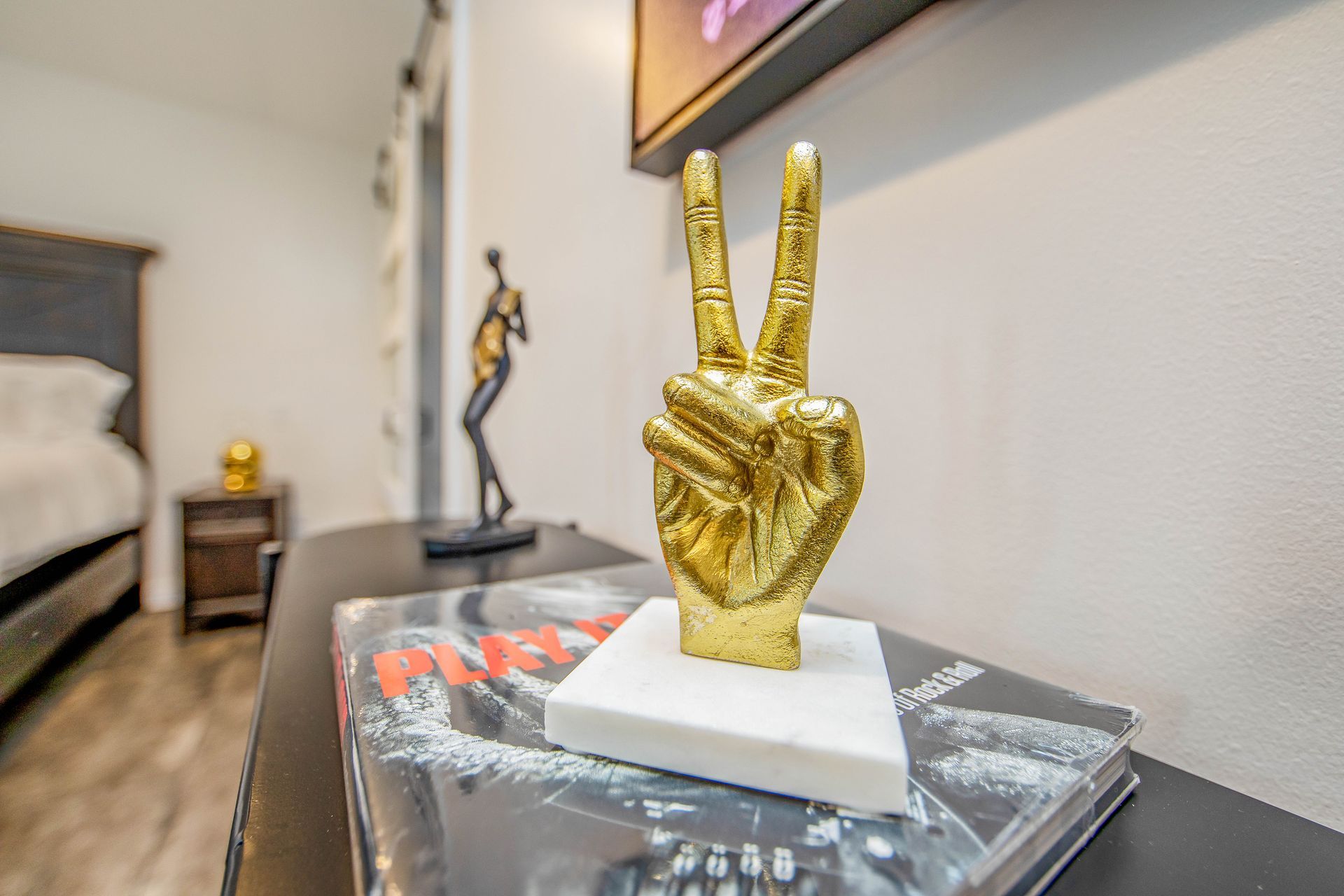 A statue of a hand giving a peace sign is on a table.