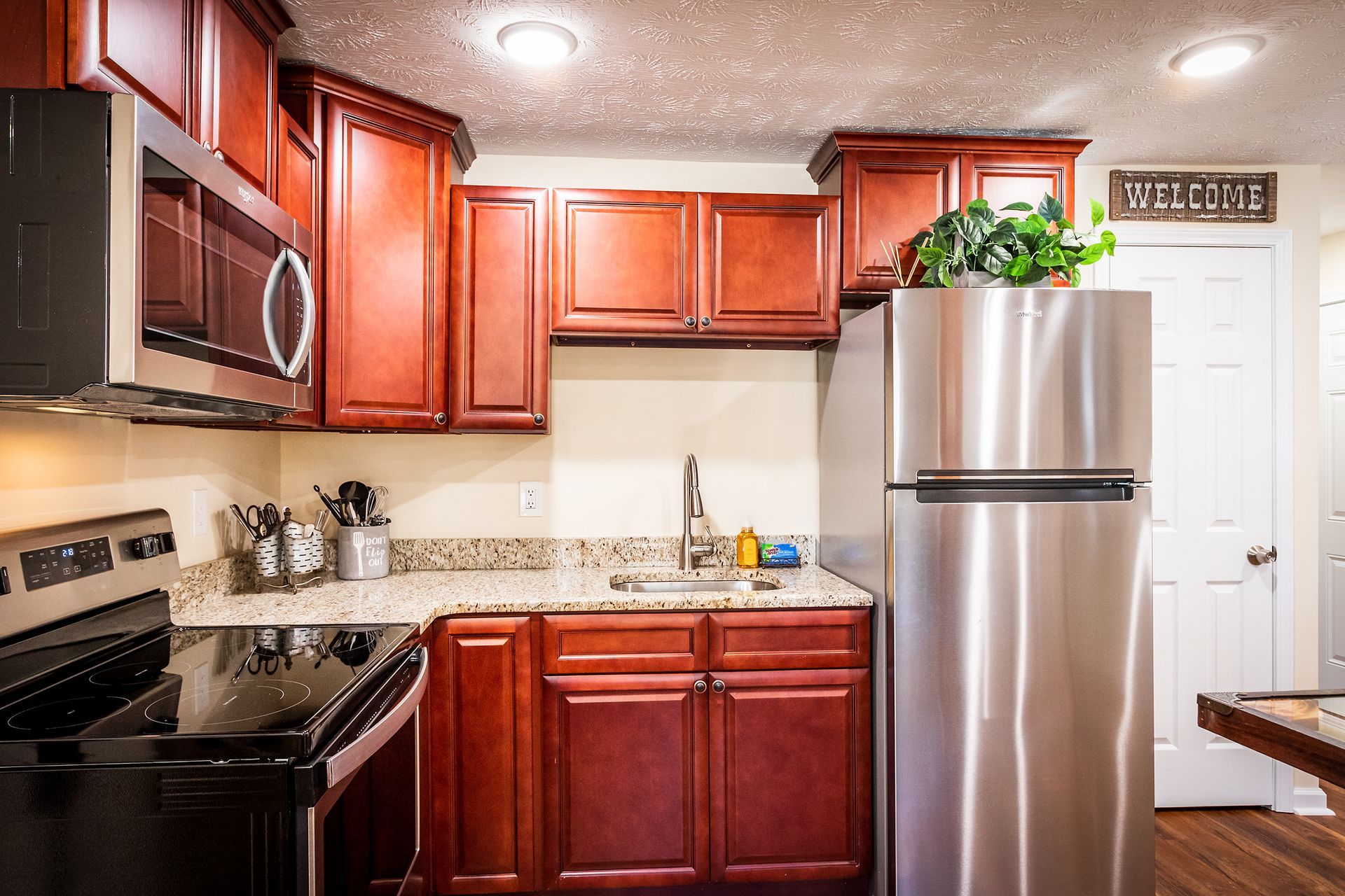 A kitchen with stainless steel appliances and wooden cabinets.