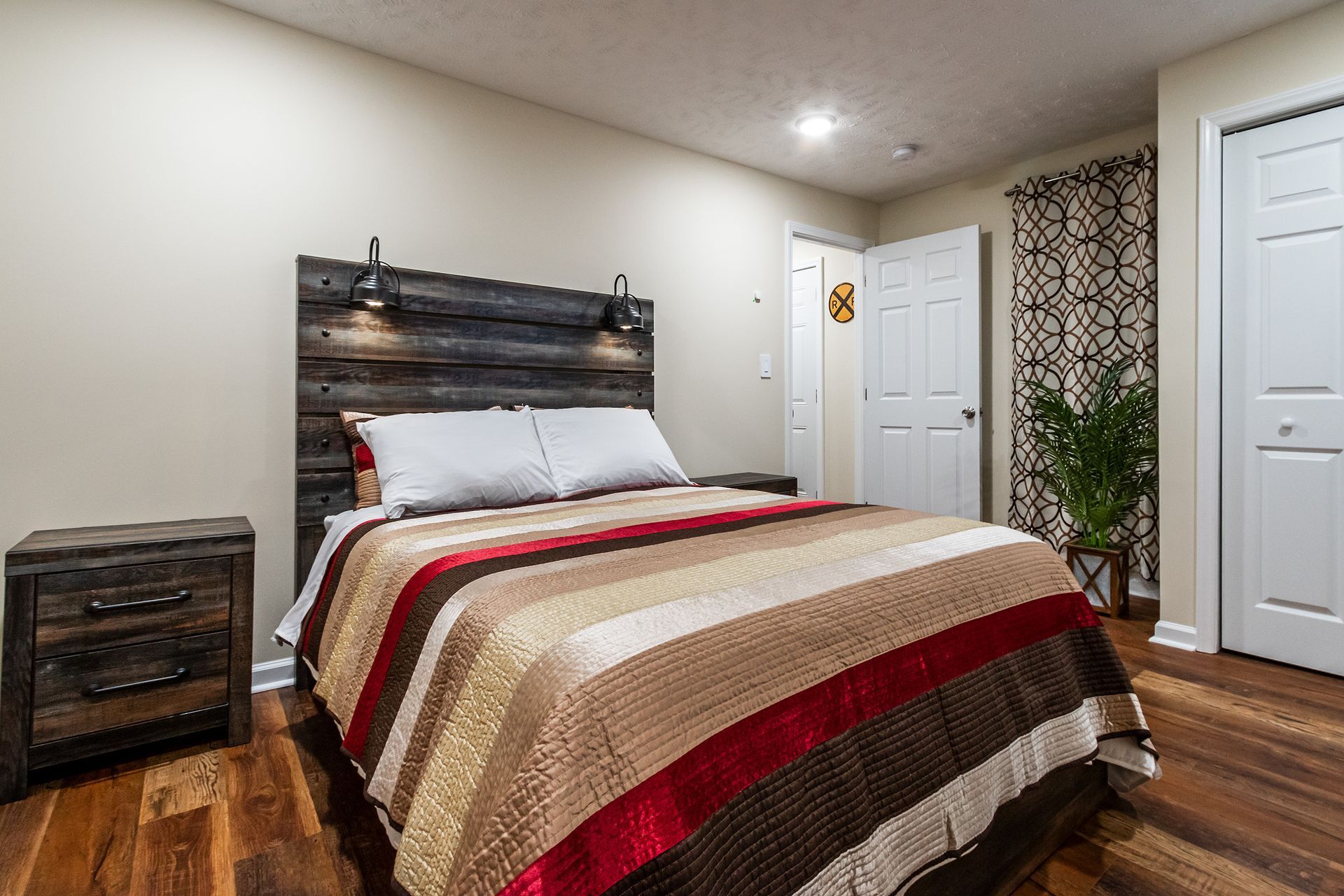 A bedroom with a bed , nightstand , and a wooden headboard.