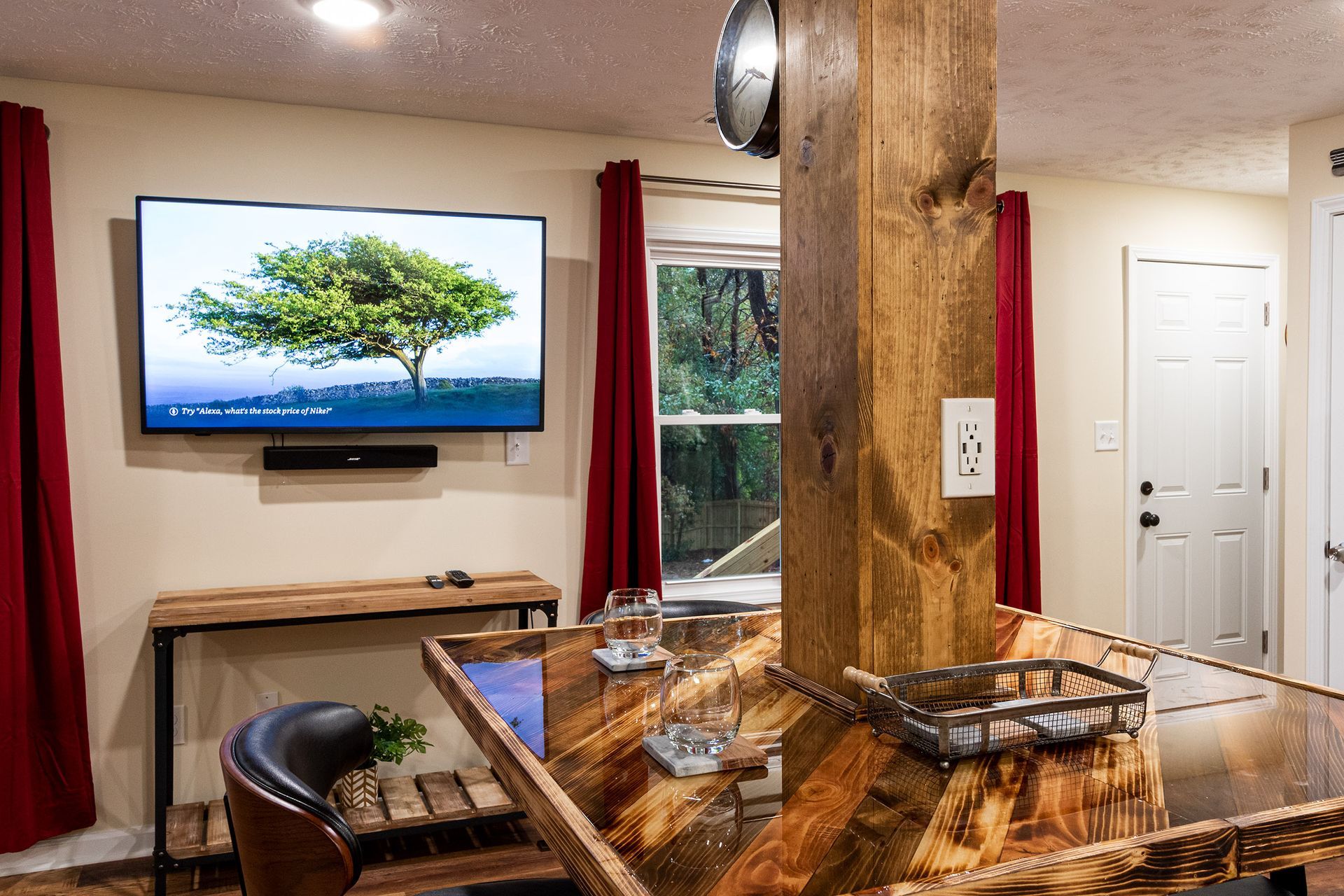 A living room with a wooden bar and a flat screen tv on the wall.