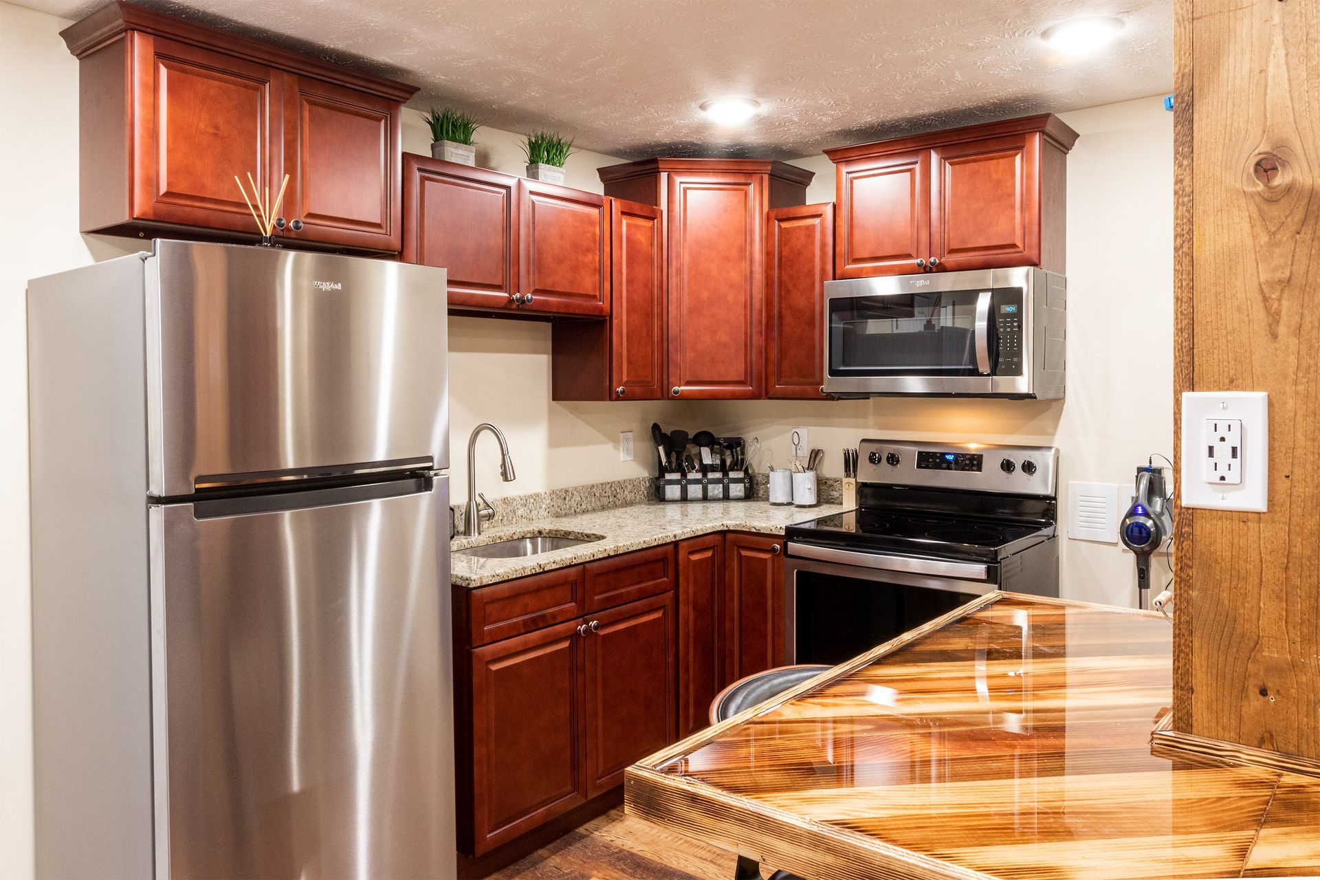 A kitchen with stainless steel appliances and wooden cabinets.