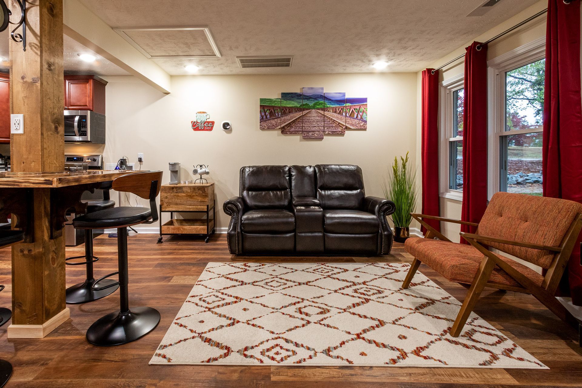 A living room with a couch , chairs , and a rug.