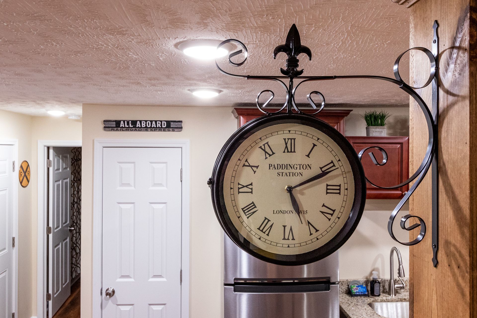 A clock is hanging on a wall in a kitchen.