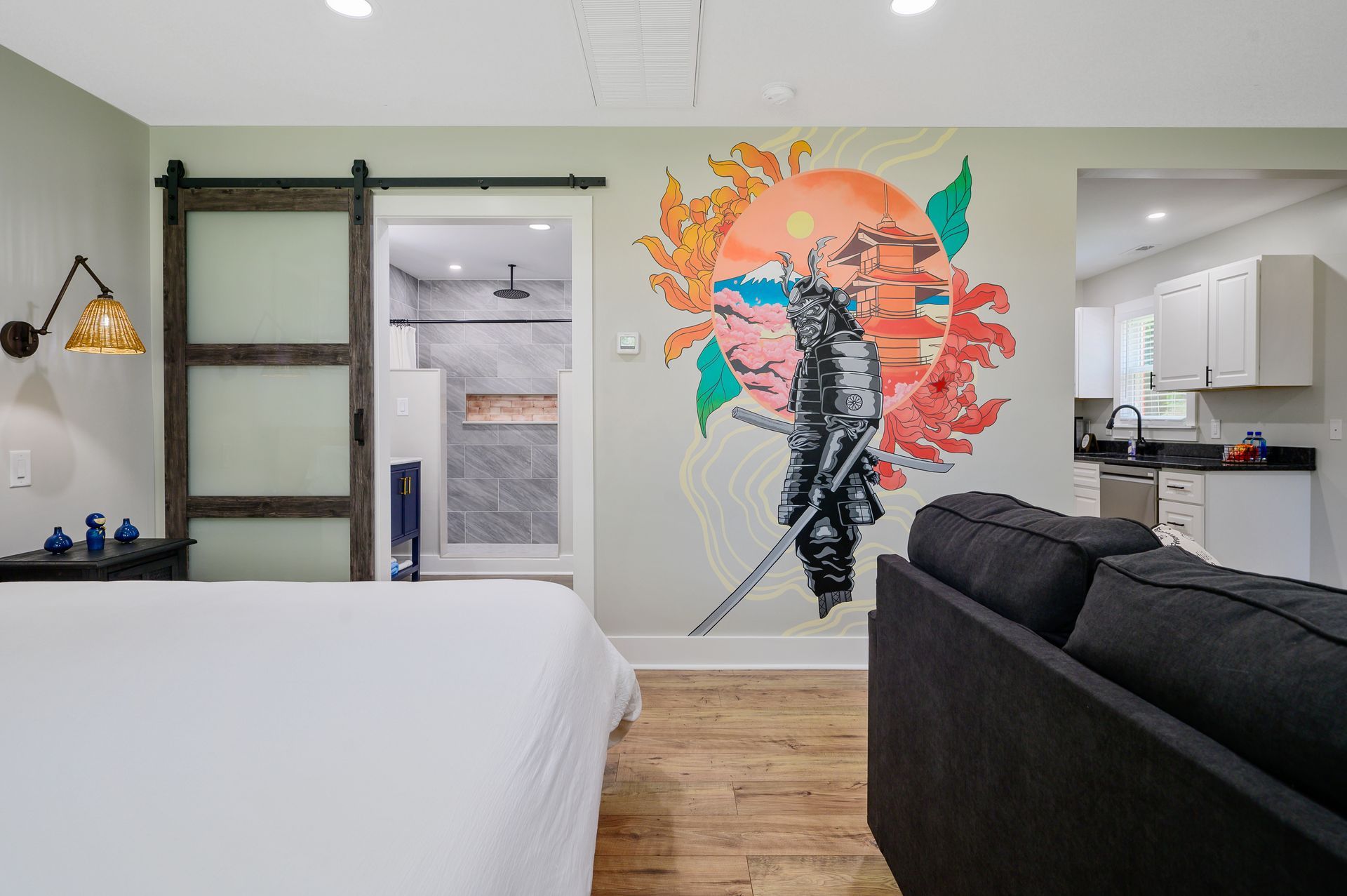 A bedroom with a bed , couch , and a painting on the wall.