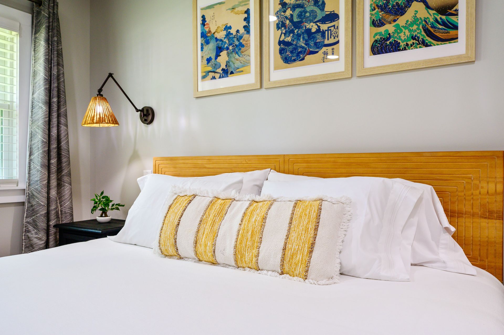 There are three pictures on the wall above the bed.