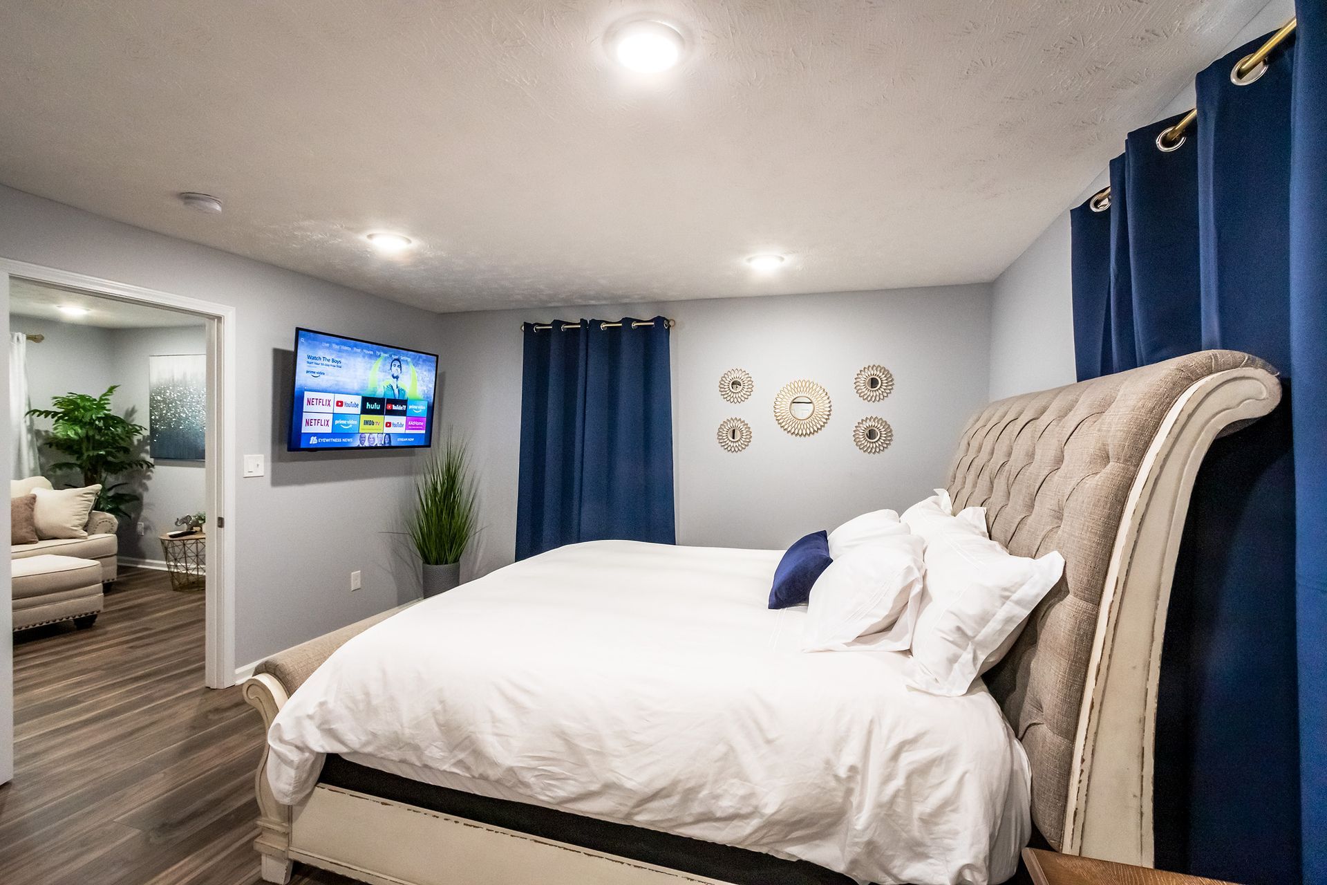 A bedroom with a large bed and a flat screen tv on the wall.