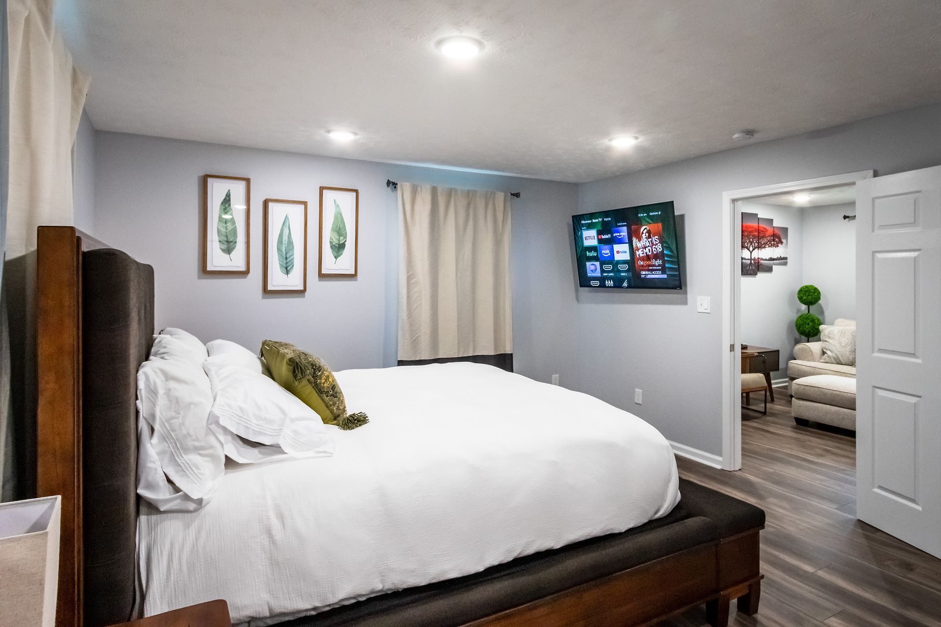 A bedroom with a king size bed and a flat screen tv on the wall.