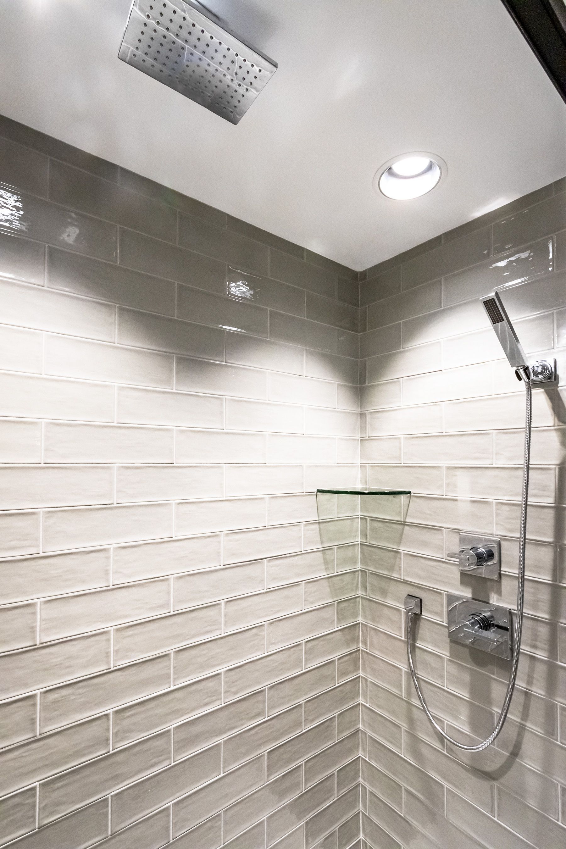 A shower with a ceiling fan and a shower head.
