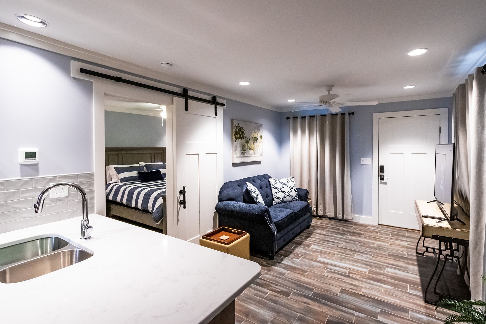 A living room with a couch , sink , and bed.