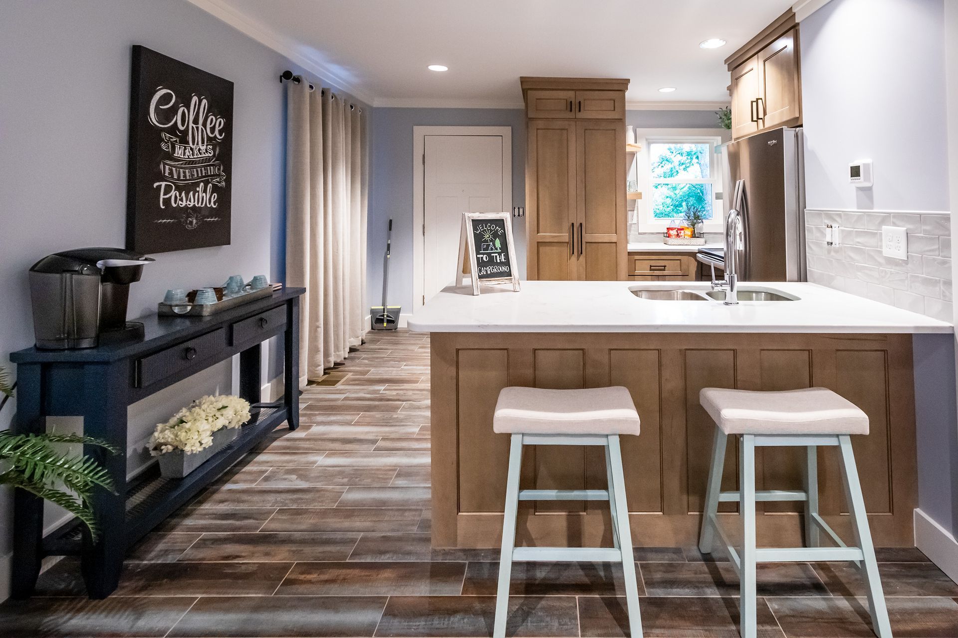A kitchen with a large island and two stools.