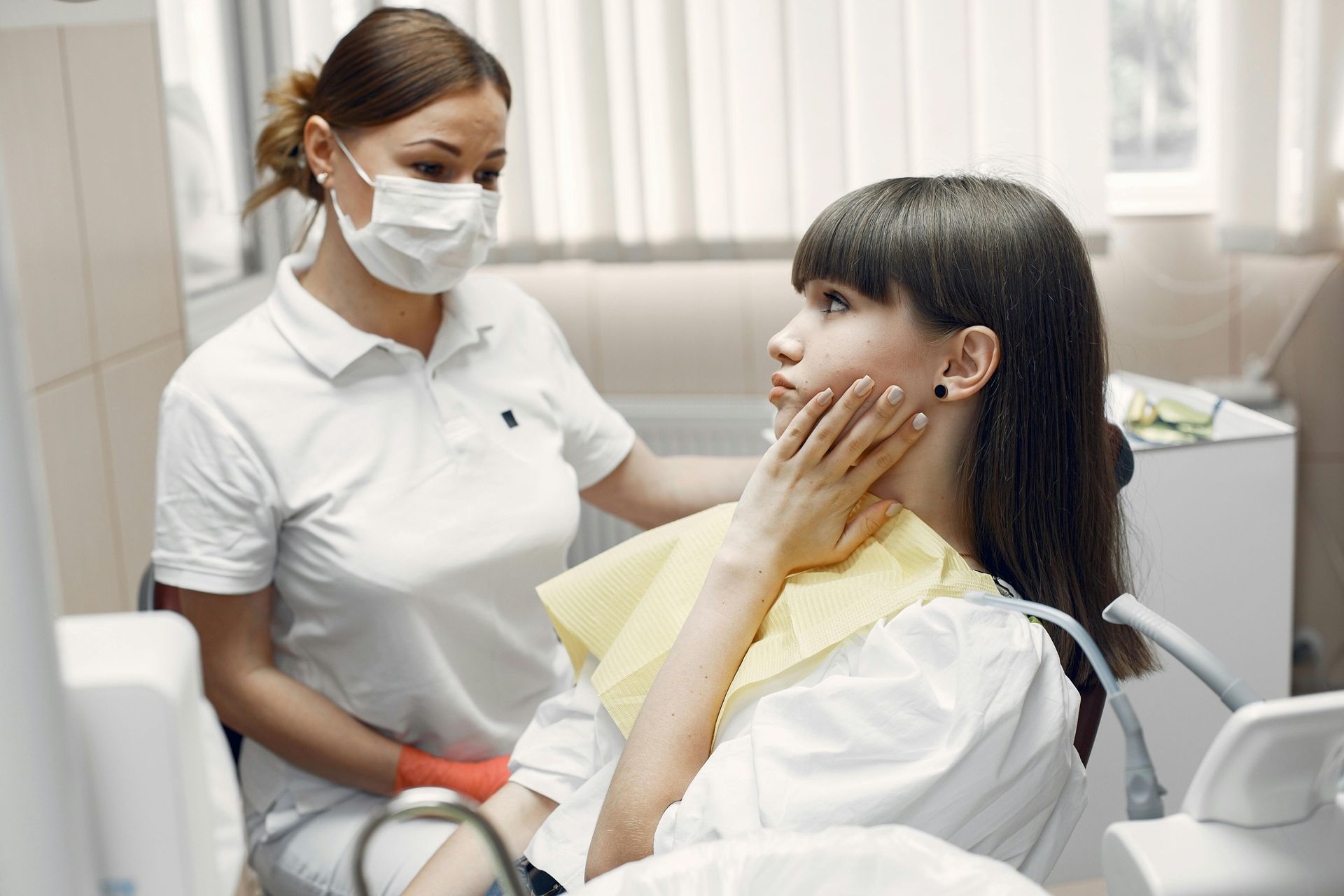 A nurse is talking to a patient in a dental office.