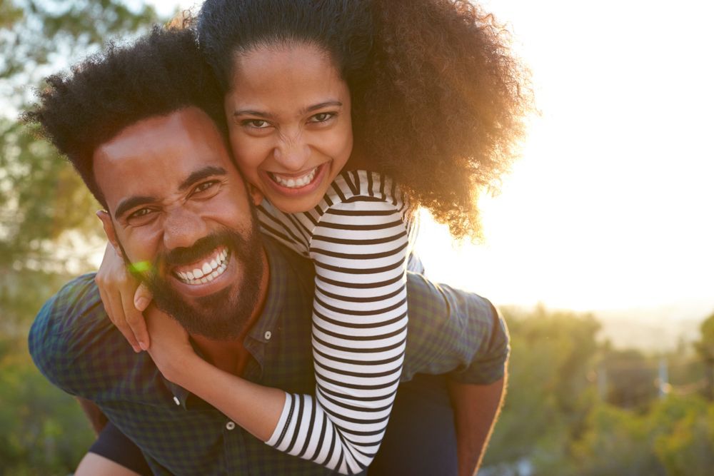 A man is carrying a woman on his back.