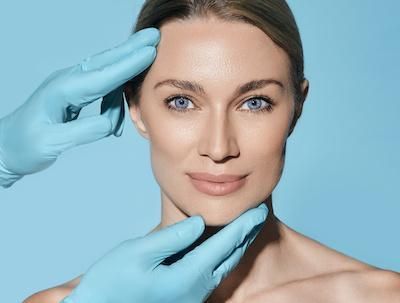 A woman is getting her face examined by a doctor.