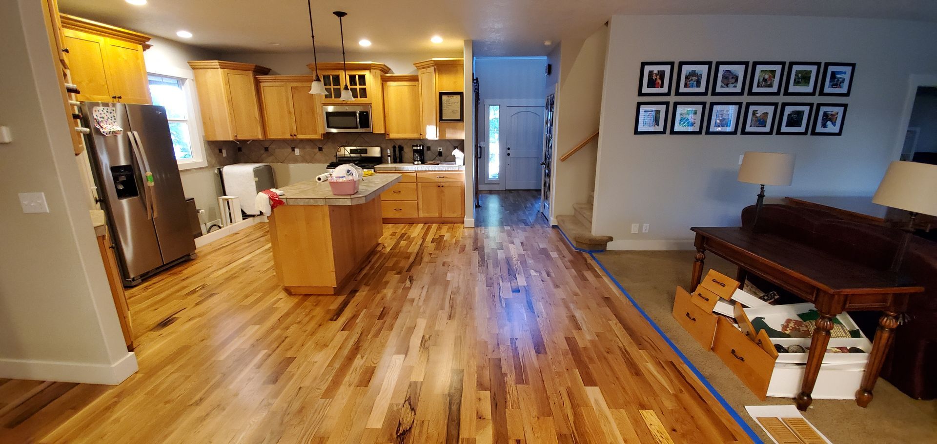 A kitchen and living room in a house with hardwood floors.