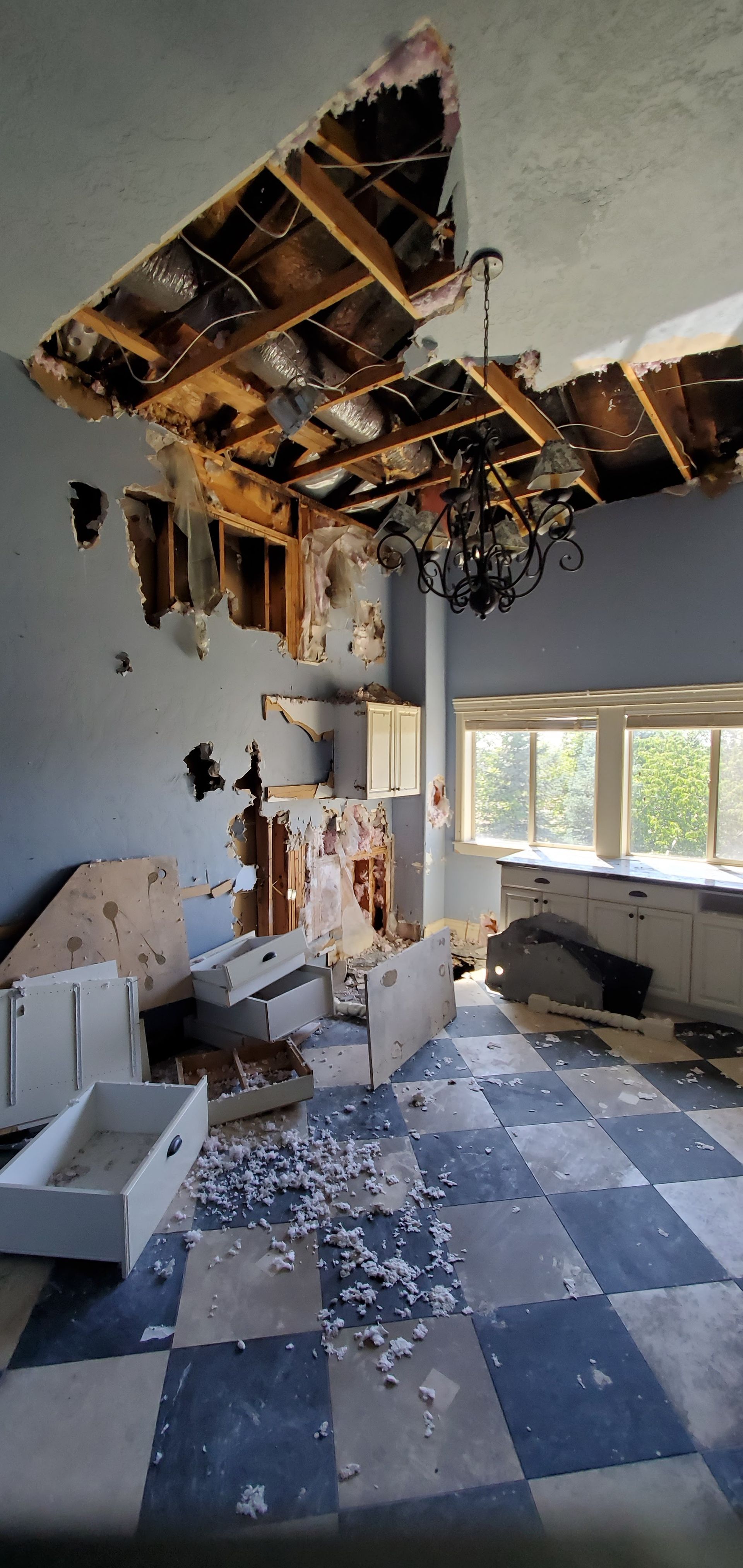 A room with a broken ceiling and a checkered floor.