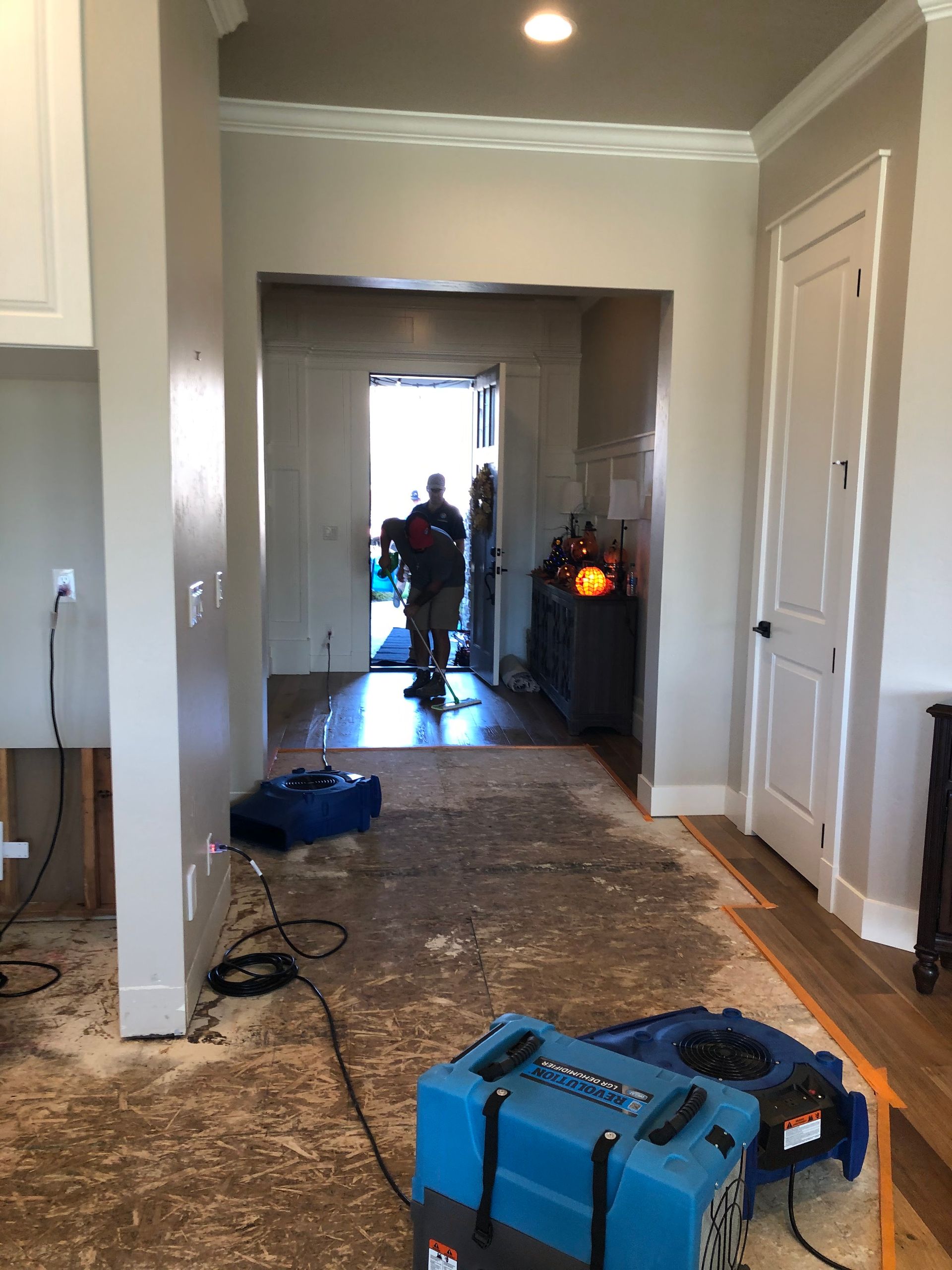 A man is standing in a hallway next to a blue box.