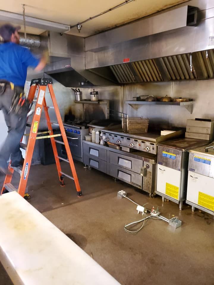 A man is standing on a ladder in a kitchen