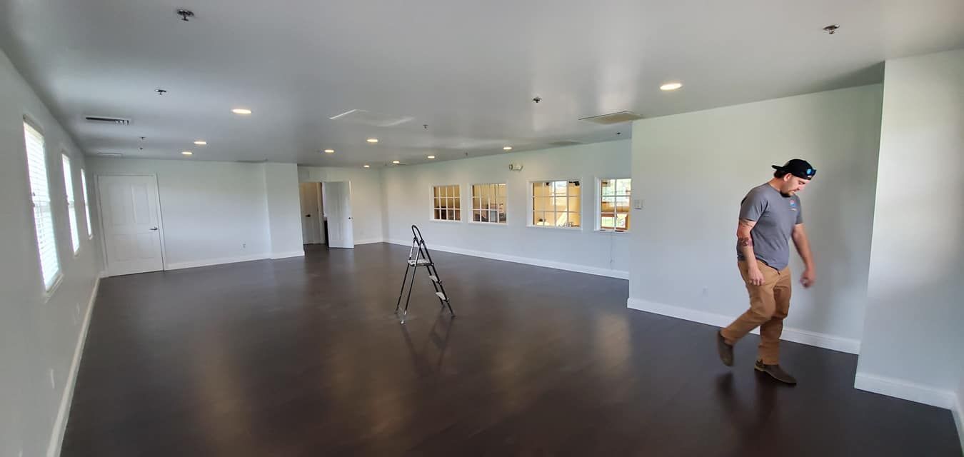 A man is walking through a large empty room.