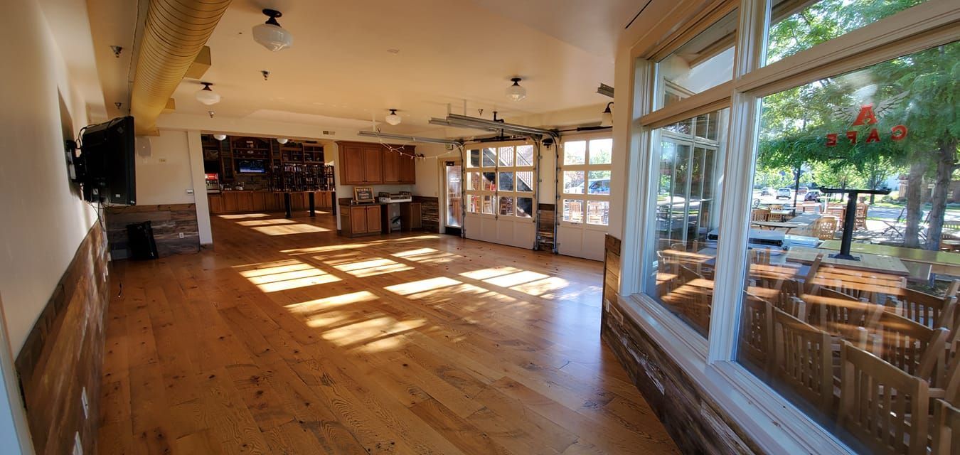 A large empty room with hardwood floors and lots of windows.