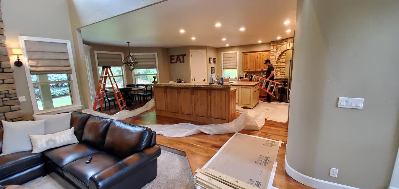A living room with a couch and a kitchen in the background.