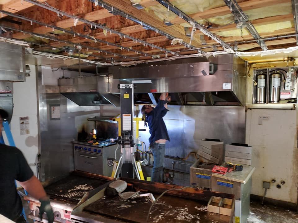 A man is working in a kitchen with a ladder.