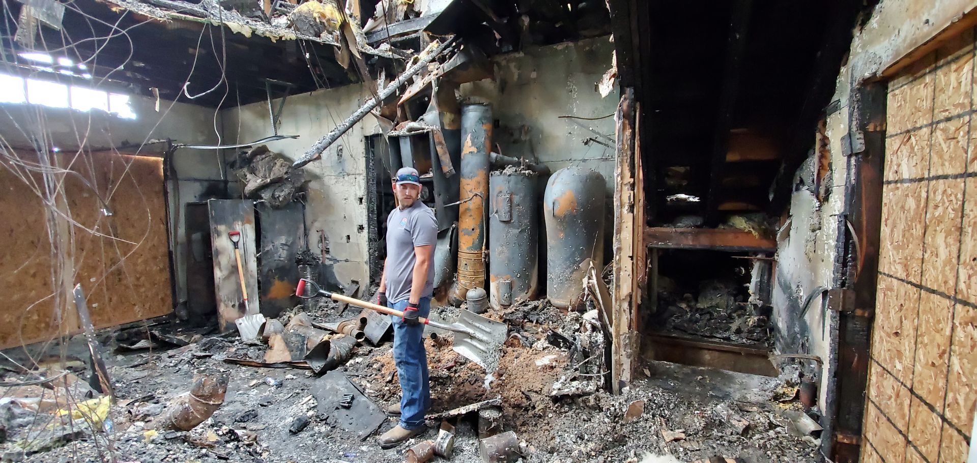 A man doing restoration work in a fire damaged house.
