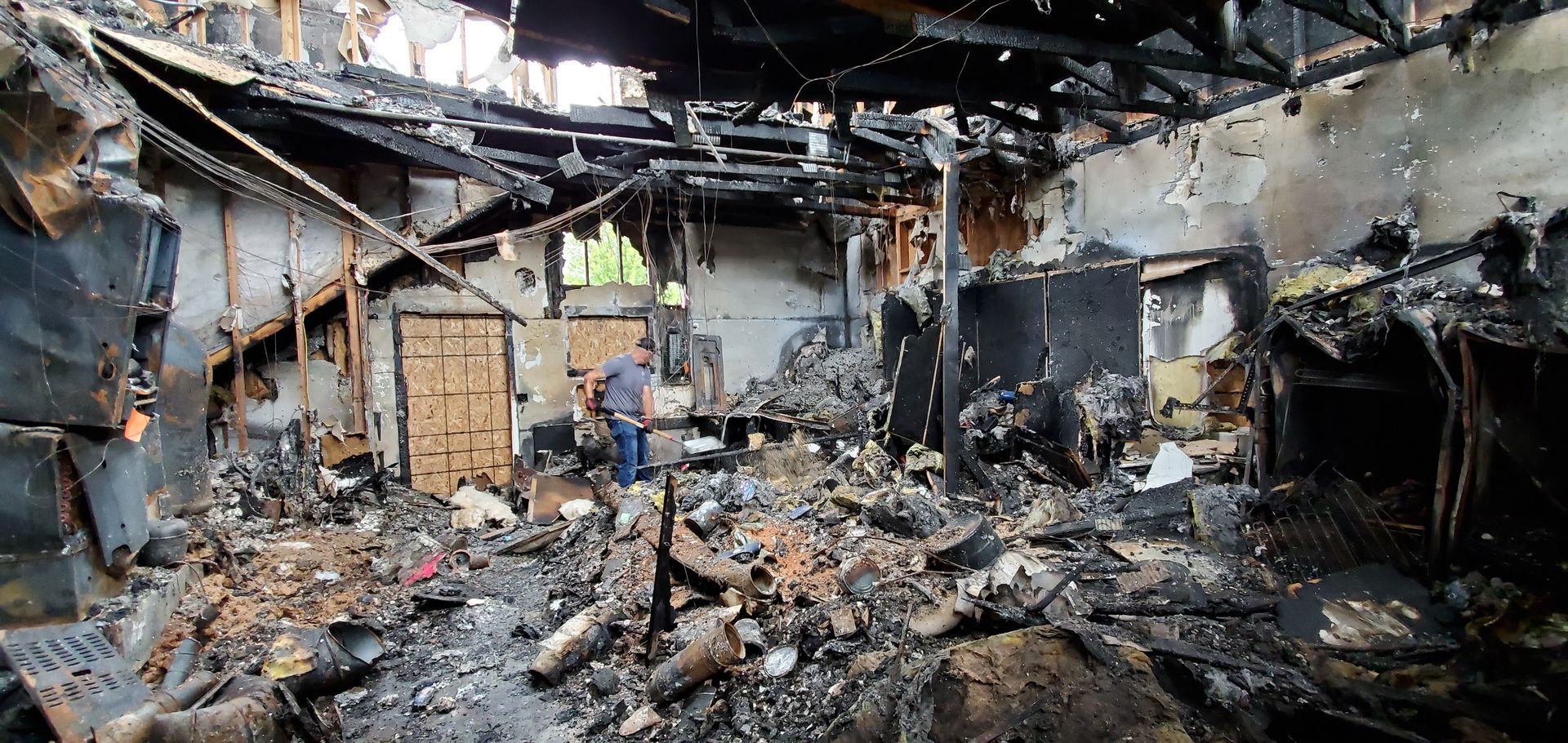 A man doing restoration work in fire damage house.