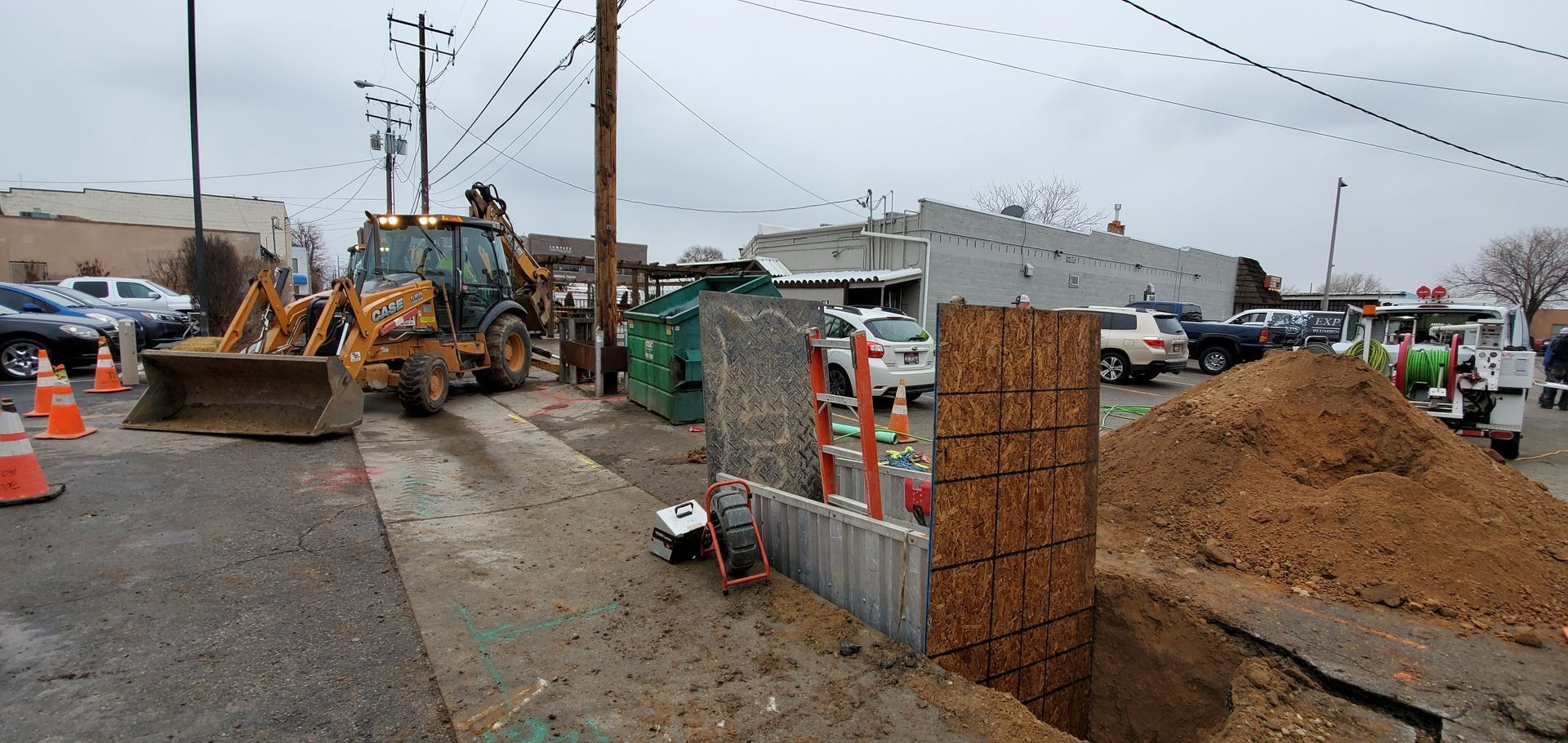A construction site with a bulldozer and a pile of dirt on the side of the road.