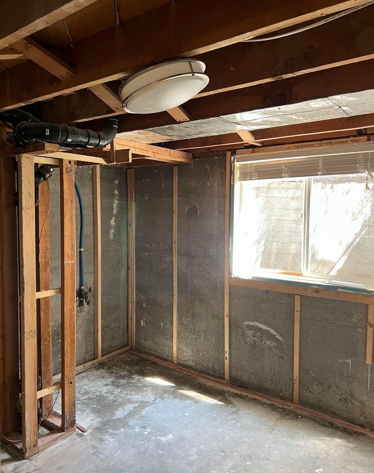 A room with a window and a light on the ceiling.