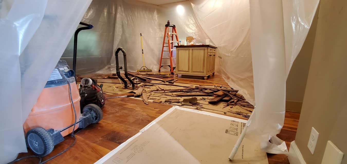 A vacuum cleaner is sitting in a room covered in plastic.