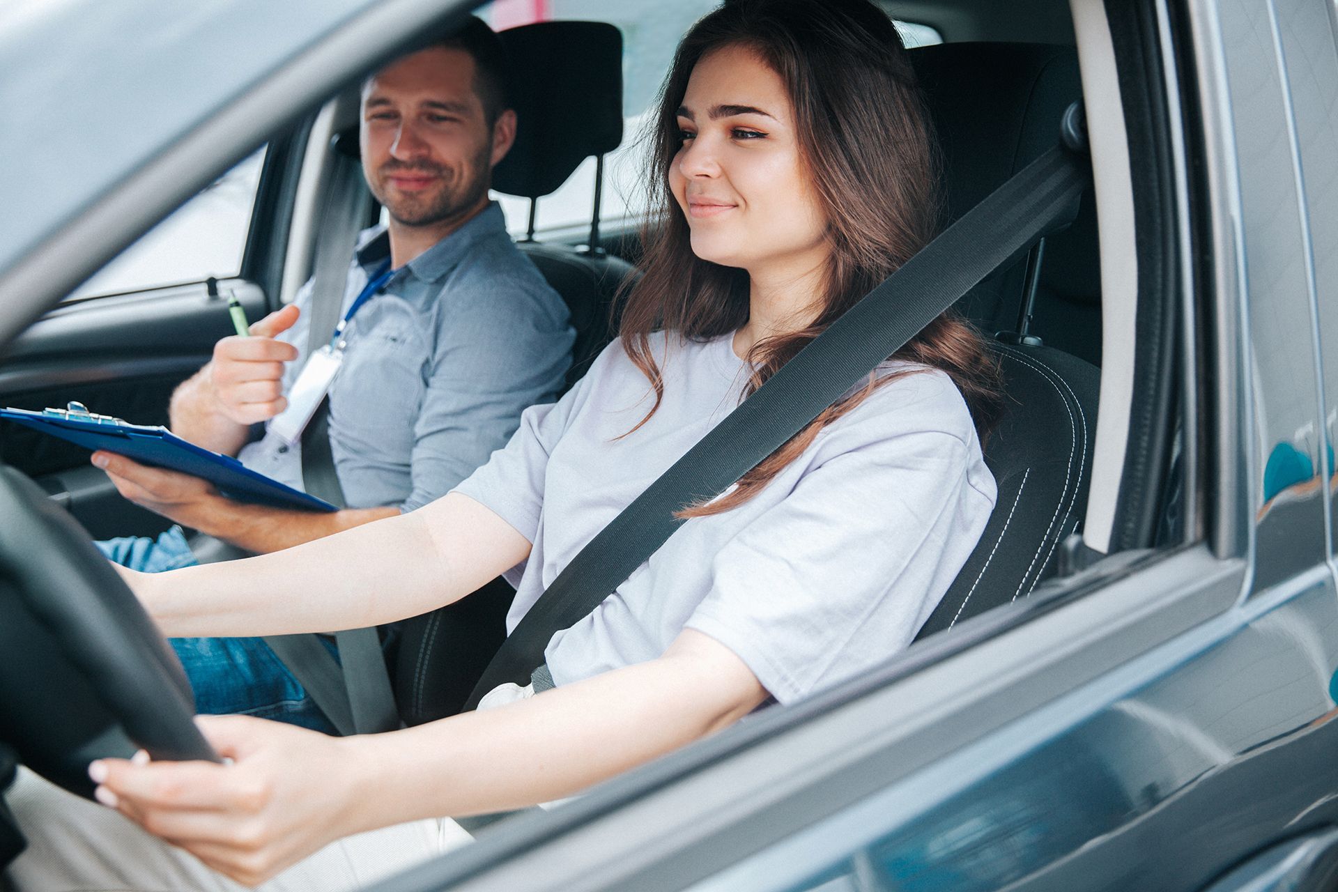 A man is teaching a woman how to drive a car.