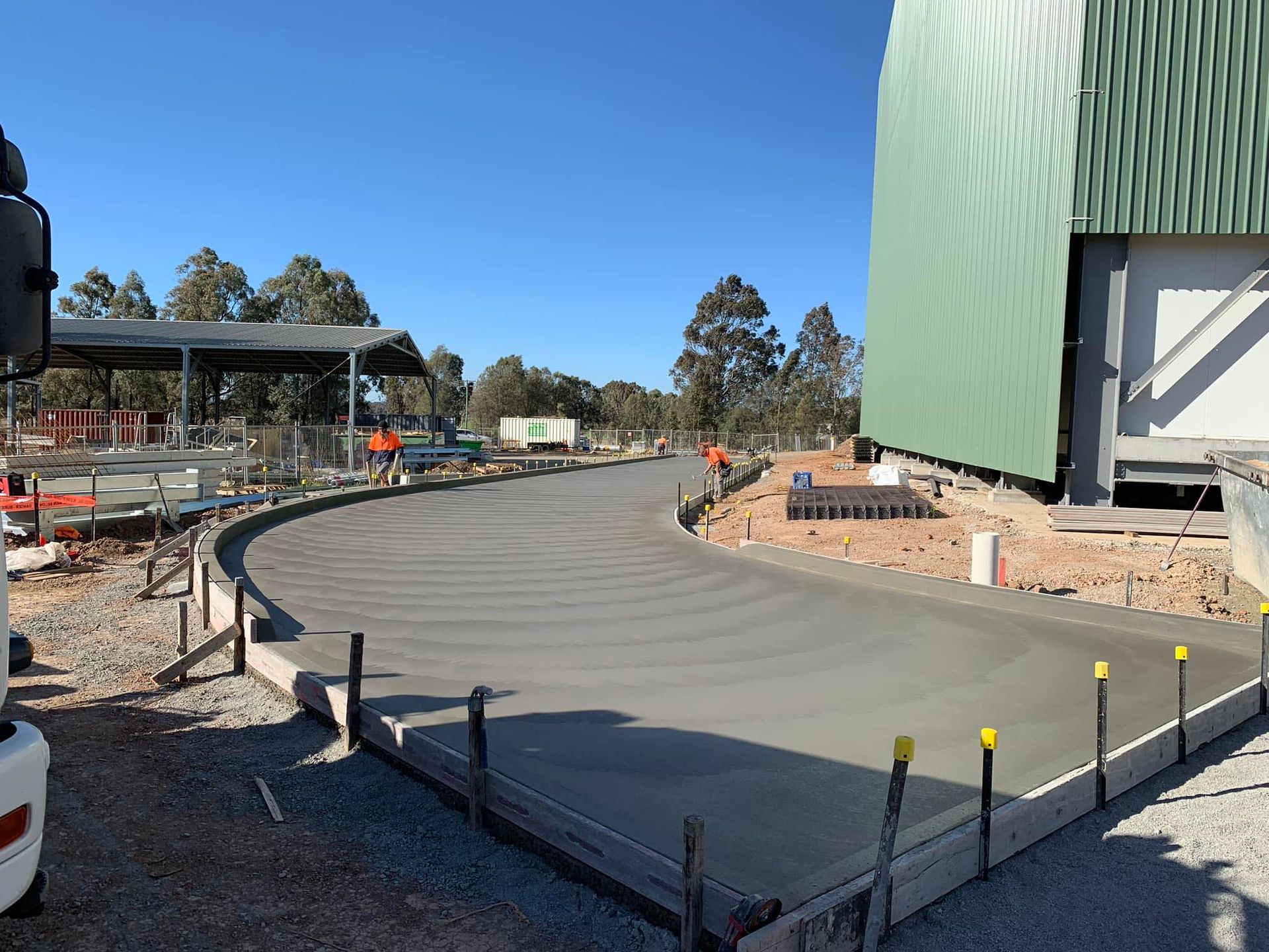 A concrete driveway is being built in front of a building.