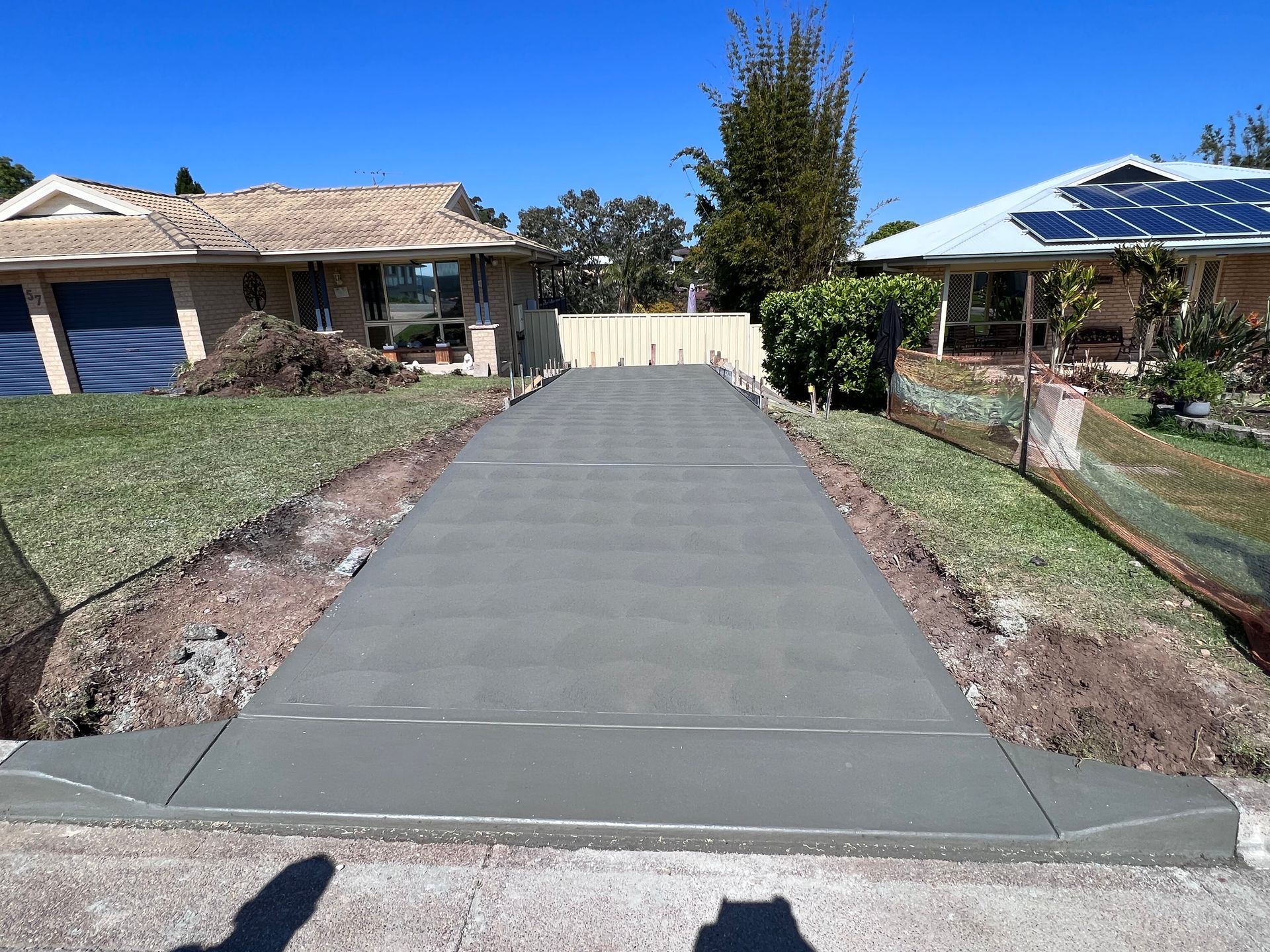 A concrete driveway is being built in front of a house.