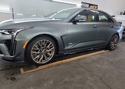 a gray car is parked on a wooden ramp in a garage .