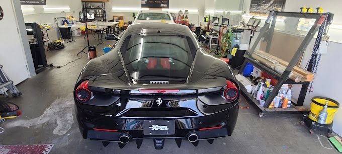 A black sports car is parked in a garage.