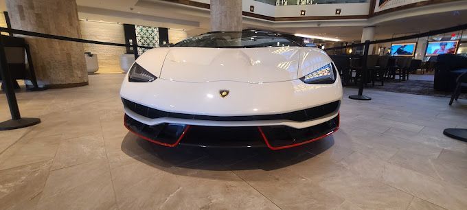 A white lamborghini is parked in a lobby of a hotel.