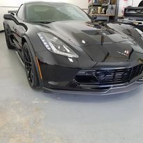 A black sports car is parked in a garage.
