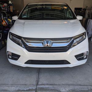 A white honda accord is parked in a garage.