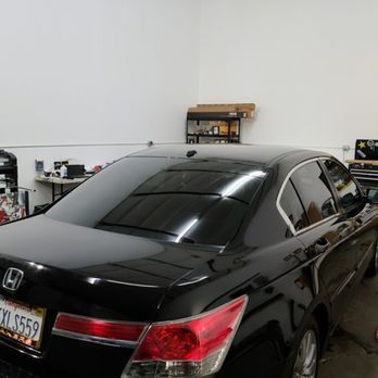 A black honda accord is parked in a garage.