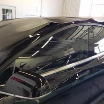 A black car is parked in a garage.