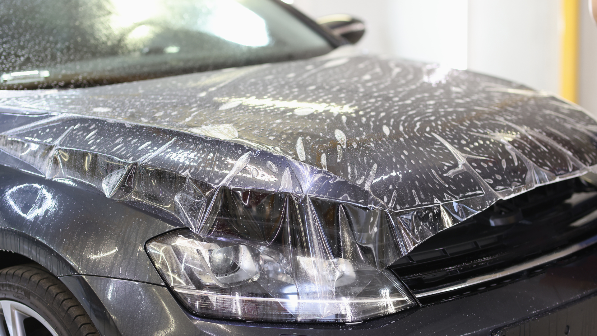 The hood of a car is covered in plastic wrap.